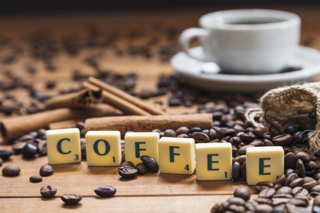 Coffee writing near beans and cinnamon