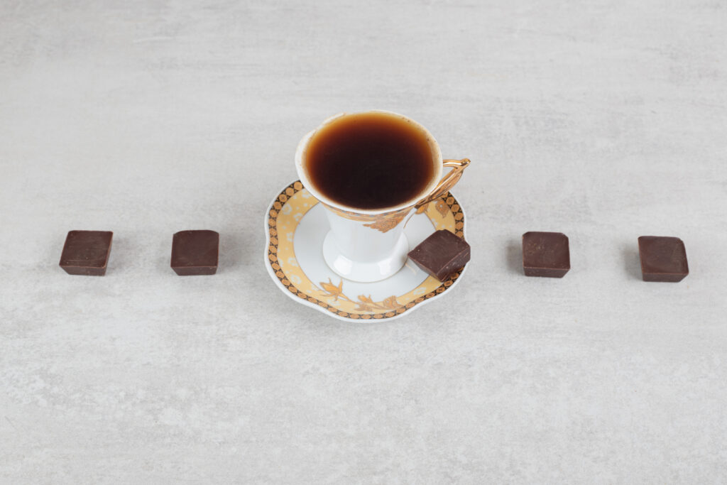 Cup of espresso with chocolate pieces 
